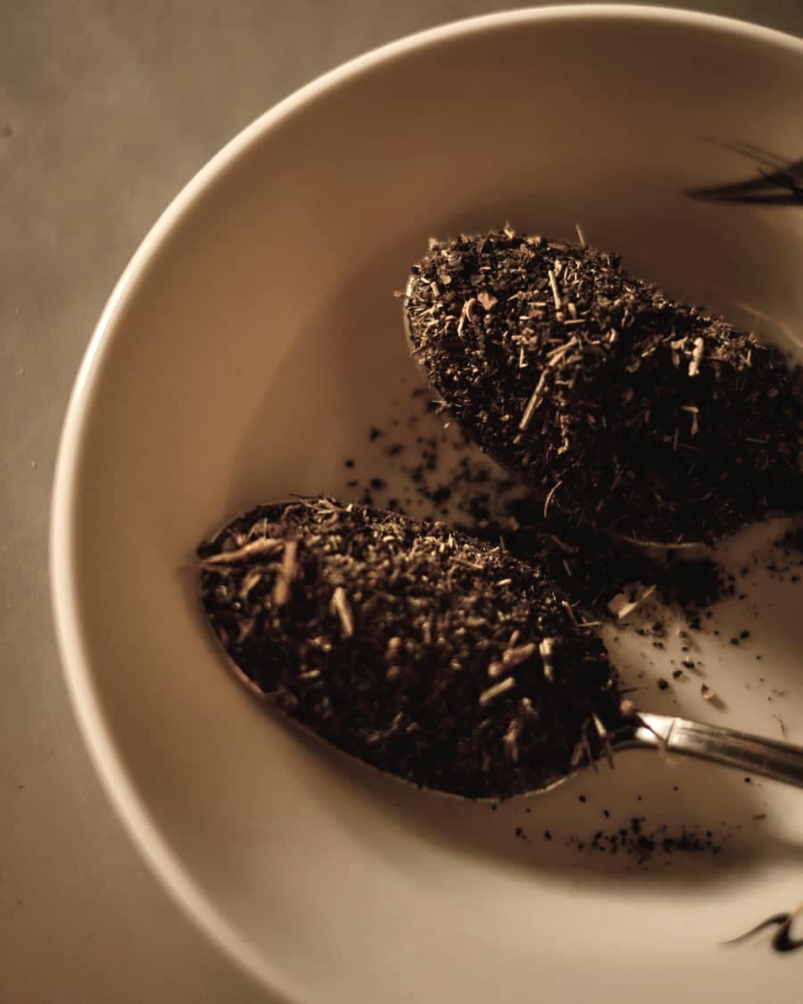 Dried herb leaves in a warm ceramic bowl with a spoon