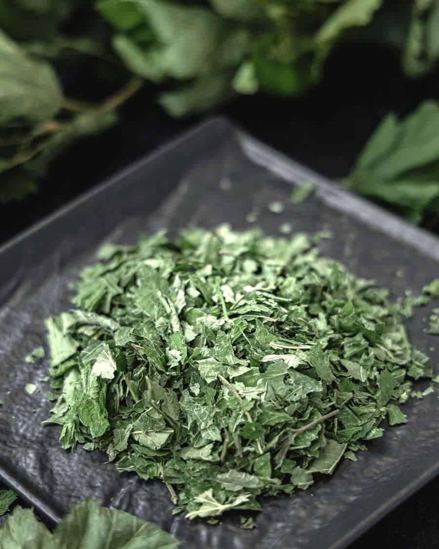 Finely chopped green herb leaves on a dark plate